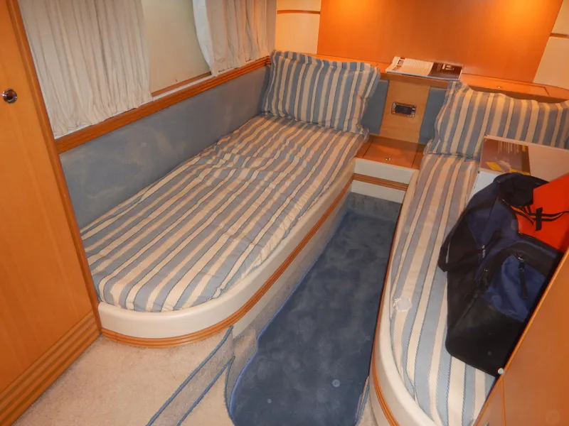 Slide: The Image of Interior cabin of 2004 Baia 54 yacht with twin striped beds and cozy decor. - 42