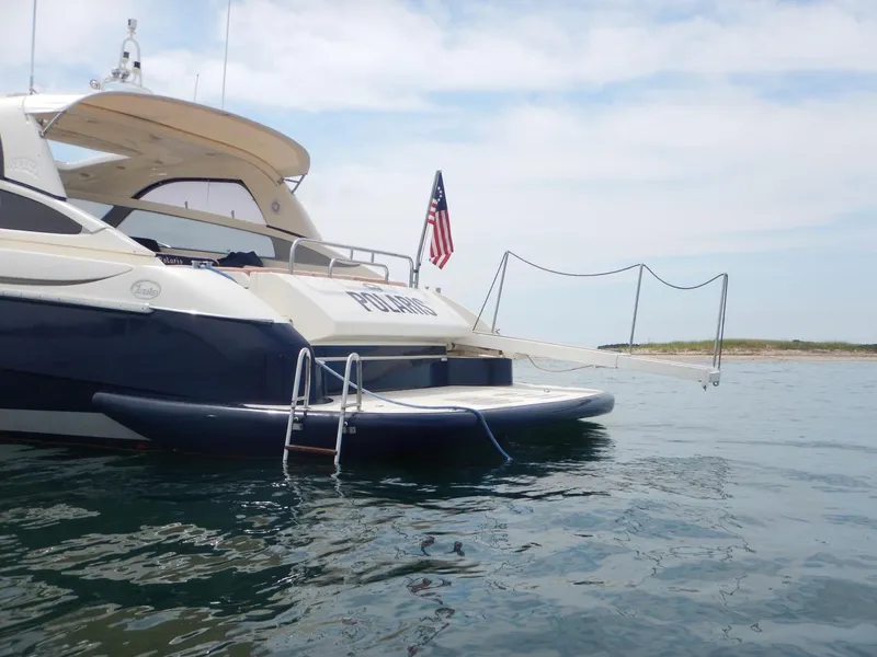 Slide: The Image of Luxury 2004 Baia 54 yacht with American flag, anchored in calm waters. - 8