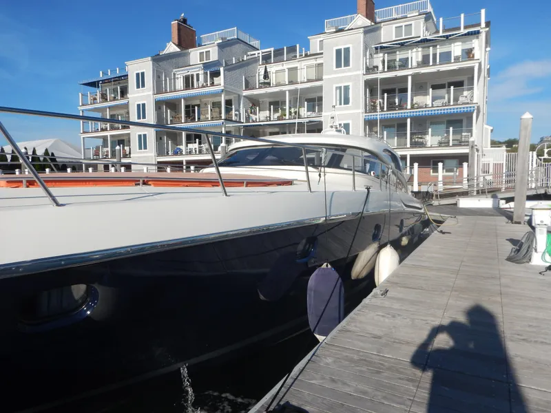 Slide: The Image of 2004 Baia 54 yacht docked near modern waterfront apartments. - 9