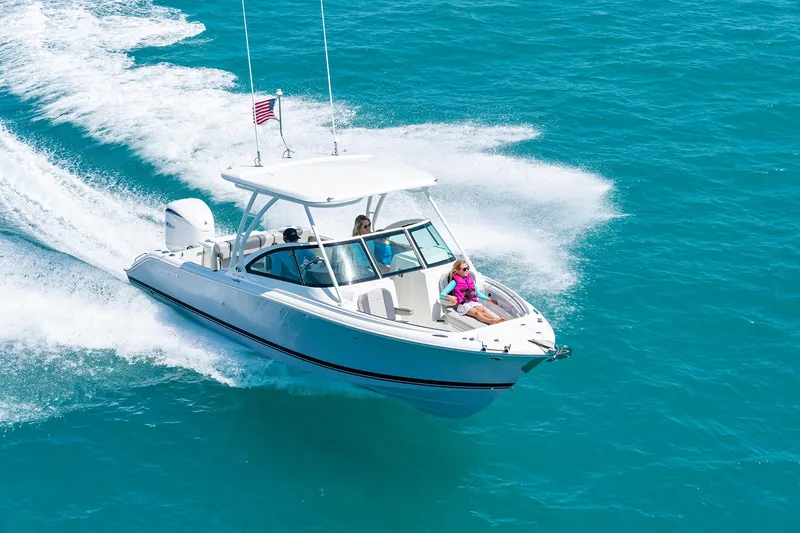 Slide: The Image of 2025 Pursuit DC 246 boat cruising on clear blue water. - 5