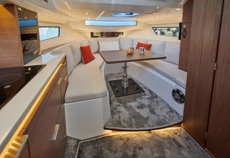 Slide: The Image of 2024 Jeanneau Leader 10.5 WA S2 interior with modern seating and dining area. - 10
