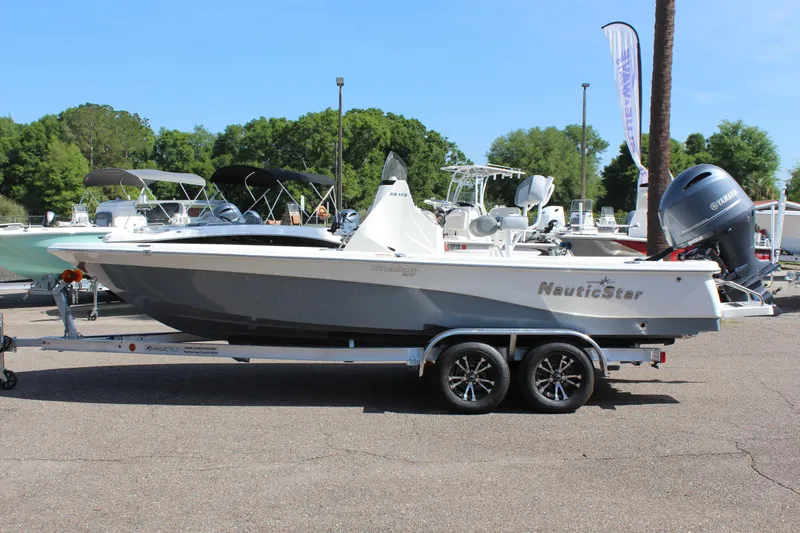 The Image of 2023 NauticStar 215 XTS boat on trailer in outdoor showroom. - 1