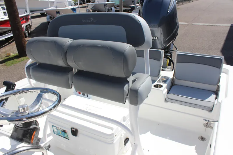 Slide: The Image of 2023 NauticStar 215 XTS boat interior with dual seats and steering wheel. - 14