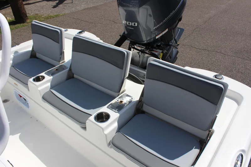 Slide: The Image of 2023 NauticStar 215 XTS boat seats with cup holders and outboard motor. - 16