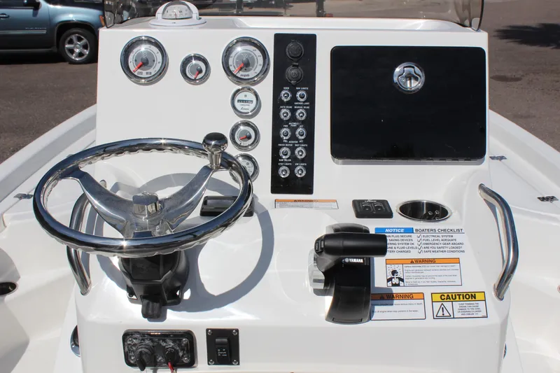 Slide: The Image of 2023 NauticStar 215 XTS boat dashboard with steering wheel and control panel. - 18