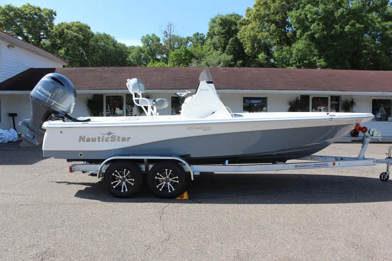 Slide: The Image of 2023 NauticStar 215 XTS boat on trailer, parked outdoors. - 6