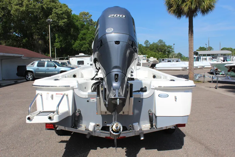 Slide: The Image of 2023 NauticStar 215 XTS boat with powerful outboard motor in a sunny marina. - 8