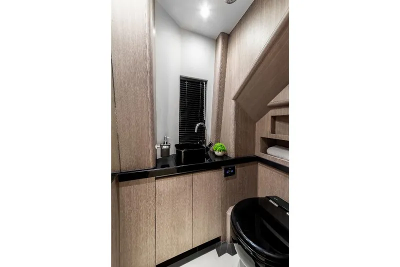 Slide: The Image of Modern bathroom in 2023 Galeon 800 Fly yacht with sleek wood cabinetry and black fixtures. - 11