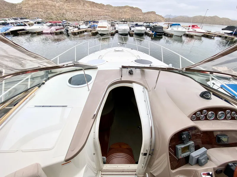 Slide: The Image of 2002 Regal 3860 Commodore yacht docked at a marina with scenic mountain backdrop. - 12