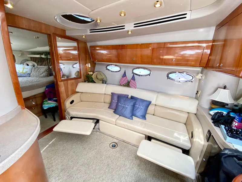 Slide: The Image of Interior of 2002 Regal 3860 Commodore yacht with beige seating and wooden cabinetry. - 15
