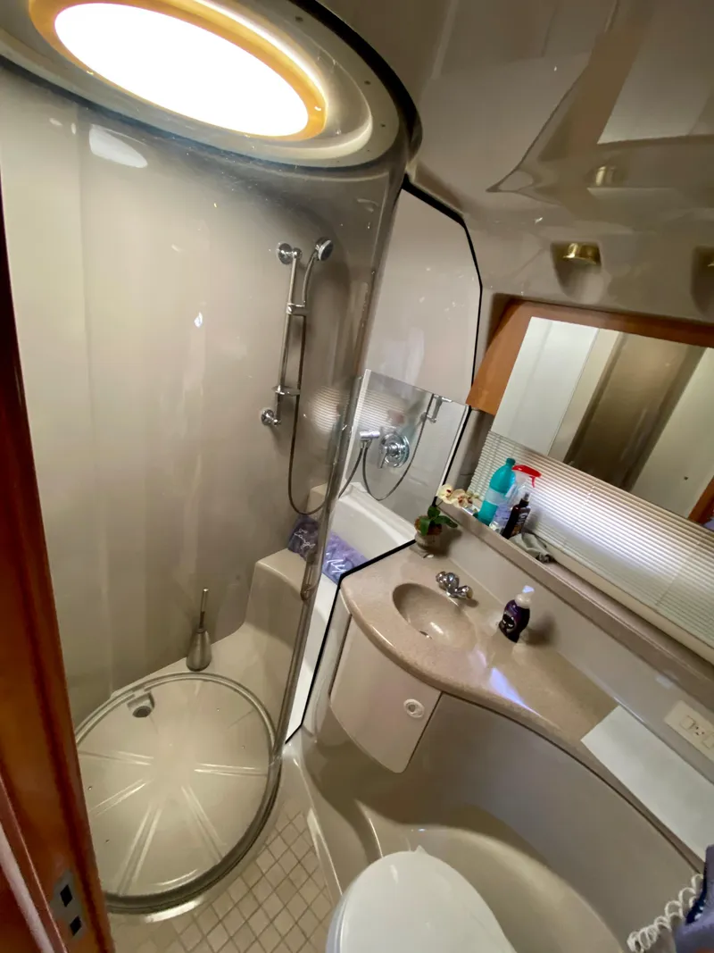 Slide: The Image of 2002 Regal 3860 Commodore yacht bathroom with shower, sink, and mirror. - 30