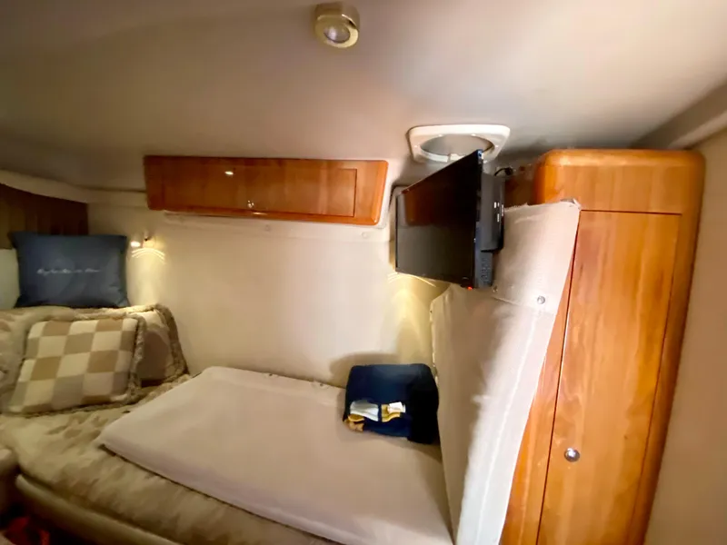 Slide: The Image of Interior cabin of 2002 Regal 3860 Commodore yacht with cozy bedding and mounted TV. - 32