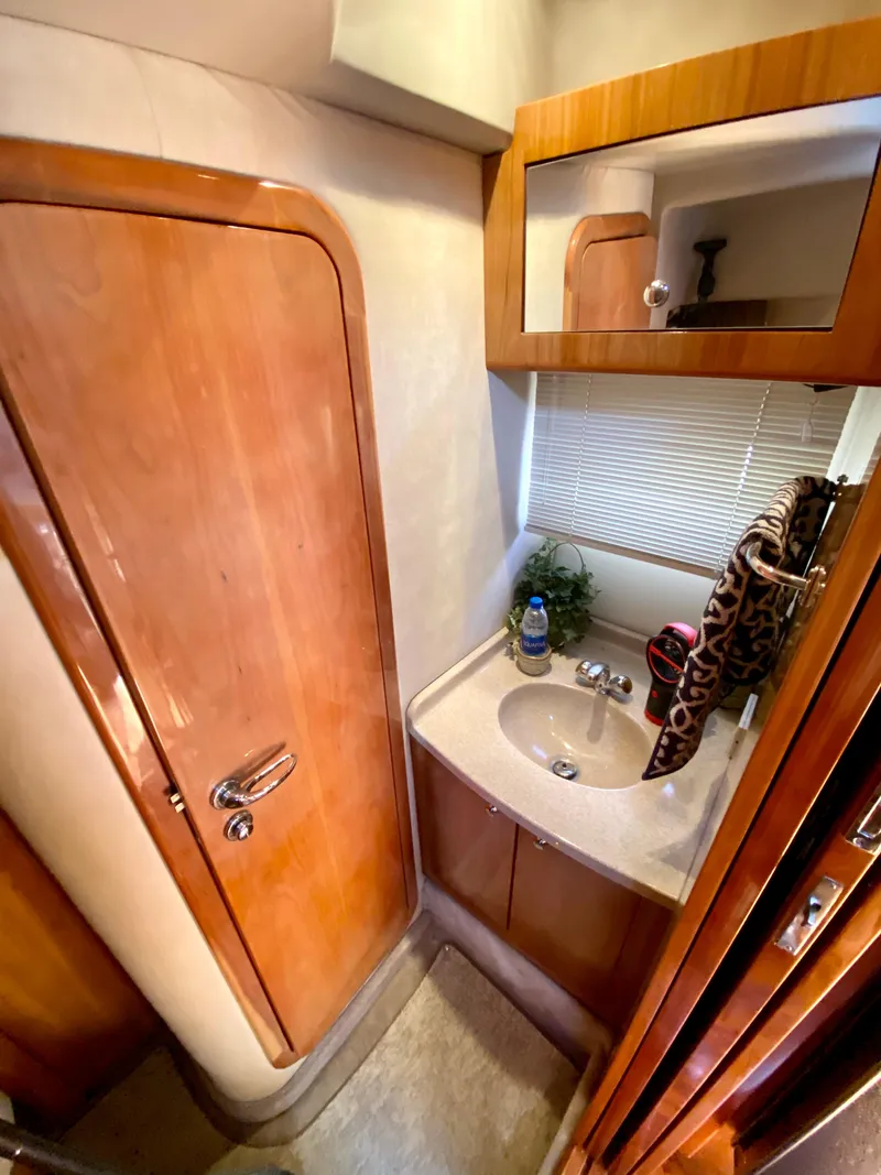 Slide: The Image of 2002 Regal 3860 Commodore yacht bathroom with wooden cabinetry and compact sink area. - 34