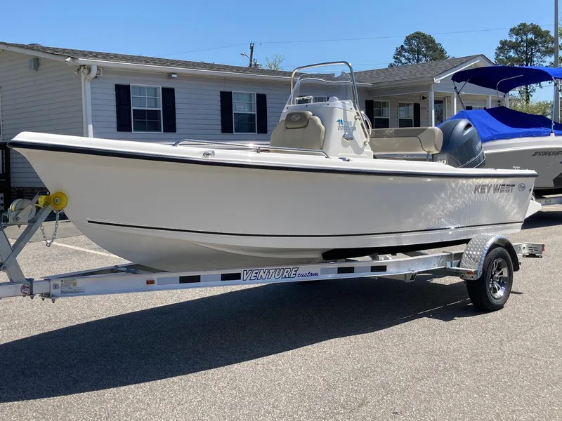 Slide: The Image of 2024 Key West 1720 Sportsman boat on a Venture trailer in a residential area. - 3