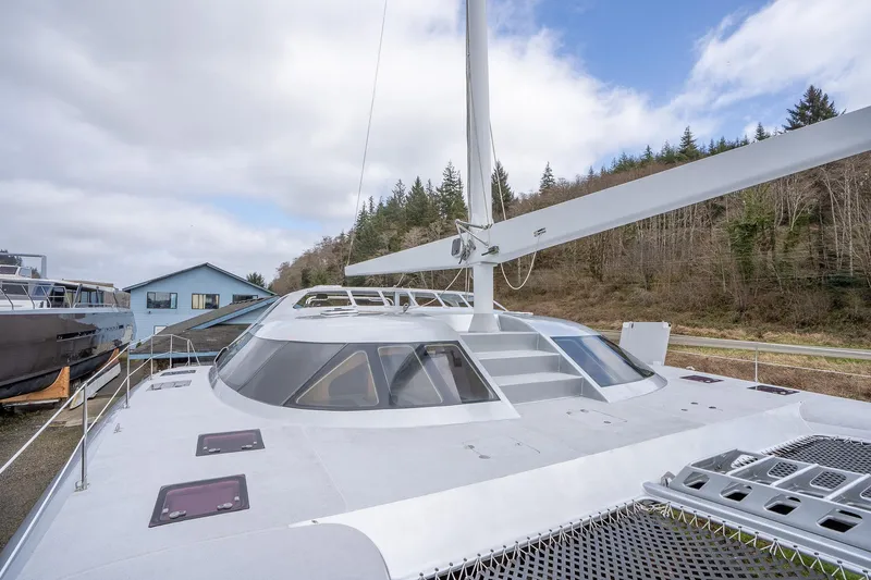 Slide: The Image of Shuttleworth 52 AeroRig 2025 yacht with sleek design, docked near forested area. - 12