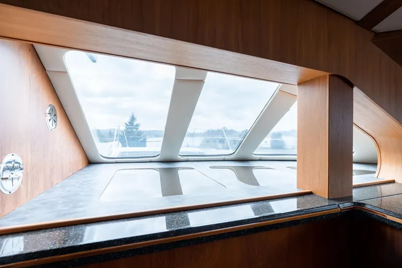 Slide: The Image of Interior view of 2025 Shuttleworth 52 AeroRig yacht, featuring sleek wooden design and large windows. - 28