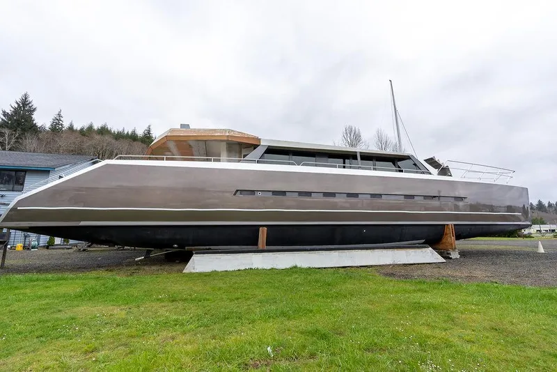Slide: The Image of 2025 Catamaran Bloomfield 86 Motorsailor on land, sleek design, overcast sky. - 1
