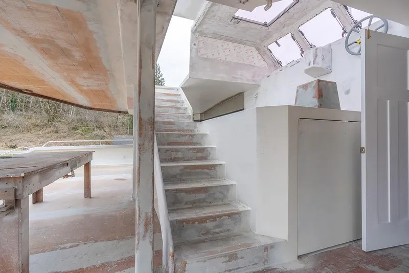 Slide: The Image of Interior view of 2025 Catamaran Bloomfield 86 Motorsailor under construction, featuring stairs and unfinished surfaces. - 15