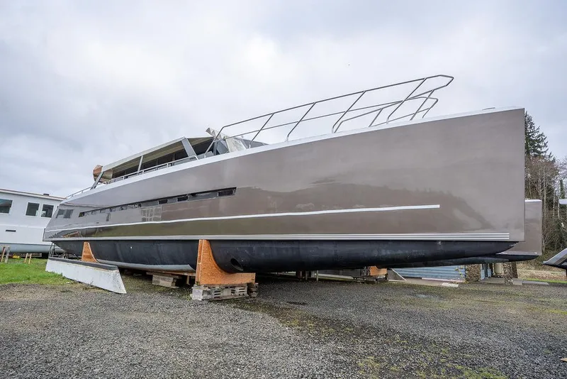 Slide: The Image of 2025 Catamaran Bloomfield 86 Motorsailor on dry dock, sleek design, gray hull. - 3