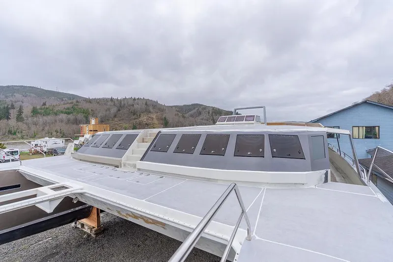 Slide: The Image of 2025 Catamaran Bloomfield 86 Motorsailor on land, showcasing sleek design and large windows. - 33