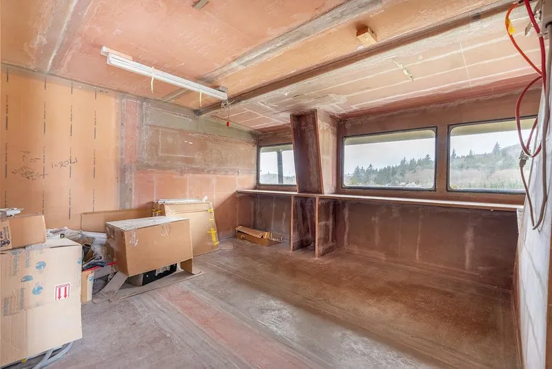 Slide: The Image of Interior of unfinished 2025 Catamaran Bloomfield 86 Motorsailor with large windows and construction materials. - 41