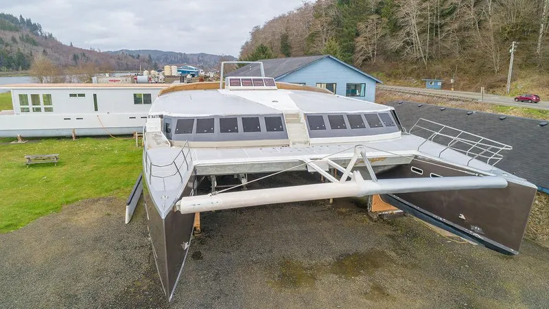 Slide: The Image of 2025 Catamaran Bloomfield 86 Motorsailor docked near a building, showcasing modern design. - 8