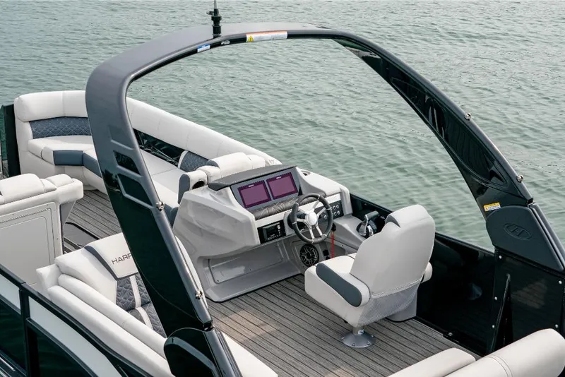 Slide: The Image of 2022 Harris Grand Mariner 250 boat interior with modern helm and seating on water. - 11