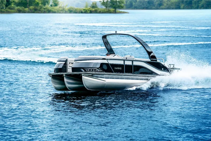 Slide: The Image of 2022 Harris Grand Mariner 250 pontoon boat cruising on a lake. - 13