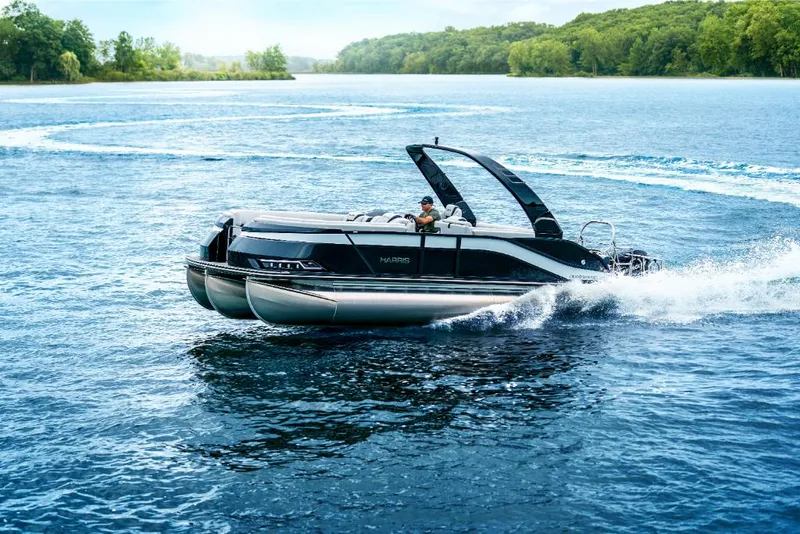 Slide: The Image of 2022 Harris Grand Mariner 250 pontoon boat cruising on a lake. - 14
