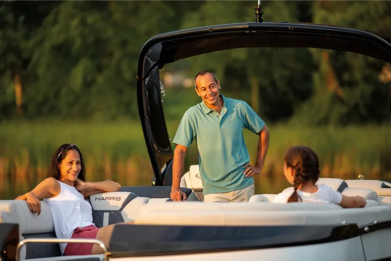 Slide: The Image of Family enjoying a 2022 Harris Grand Mariner 250 boat on a sunny day. - 21