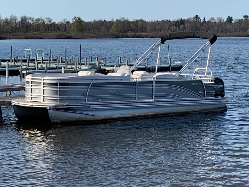 Slide: The Image of 2014 Harris Solstice 240 pontoon boat docked on a calm lake. - 11