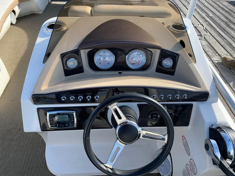 Slide: The Image of 2014 Harris Solstice 240 boat dashboard with steering wheel and gauges. - 4