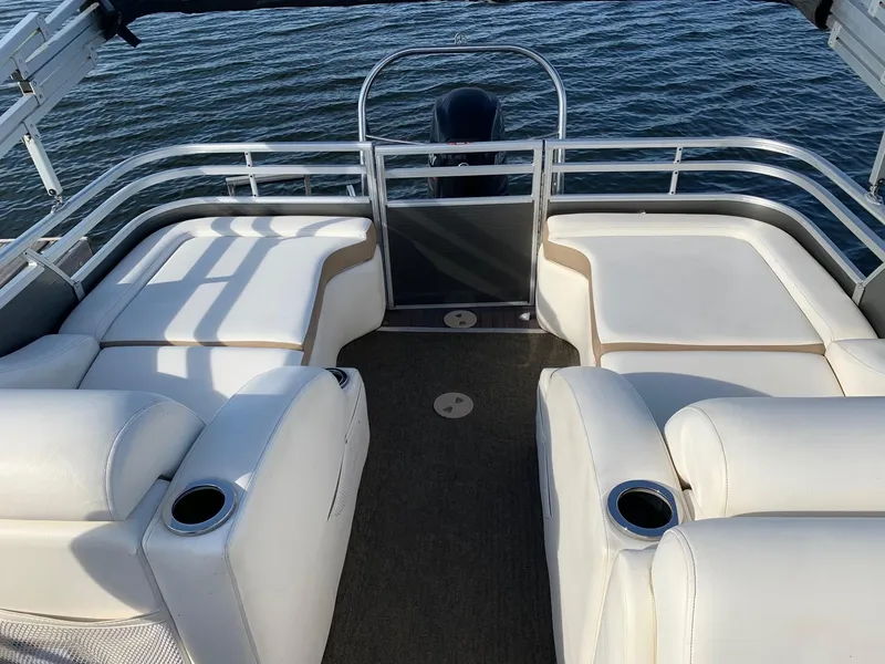 Slide: The Image of 2014 Harris Solstice 240 pontoon boat with white seating, cup holders, and lake view. - 7