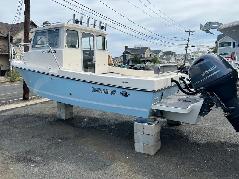 Slide: The Image of 2024 Defiance 220 Admiral EX boat on blocks with Yamaha outboard motor. - 2