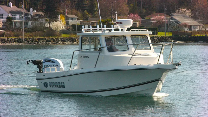 Slide: The Image of 2024 Defiance 220 Admiral EX boat cruising on a calm lake near residential area. - 4