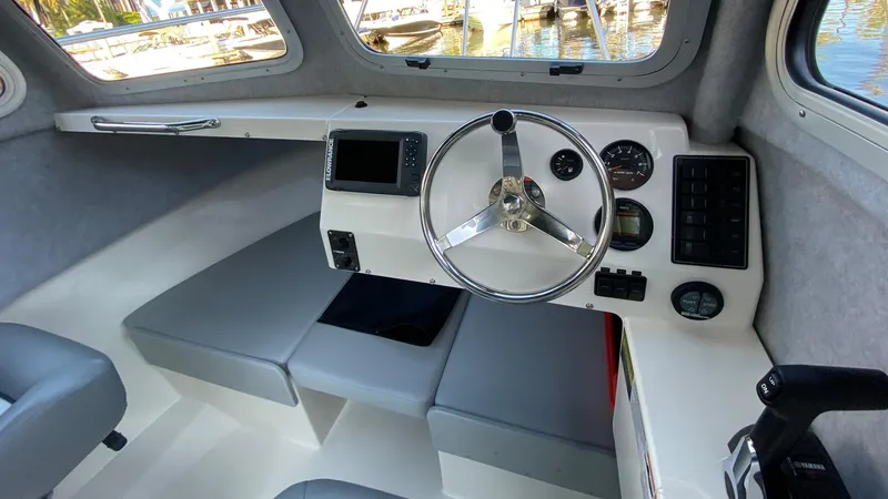 Slide: The Image of 2024 Defiance 220 Admiral EX boat interior with steering wheel and control panel. - 6