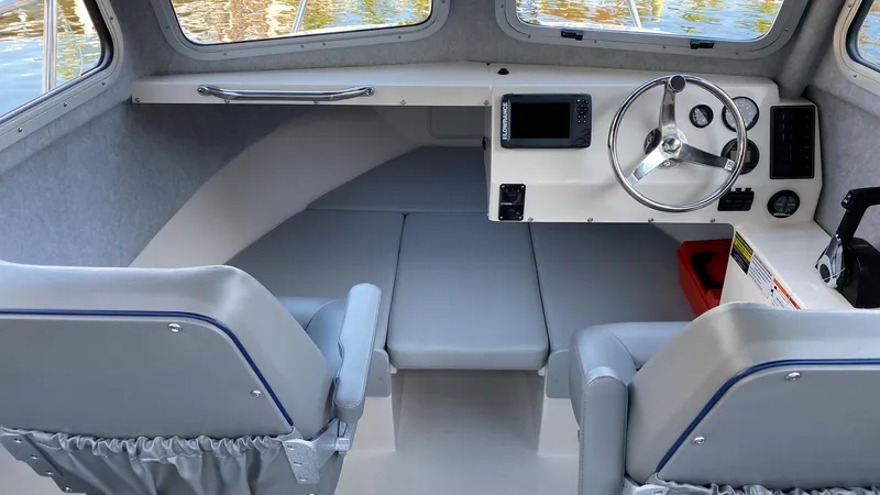 Slide: The Image of 2024 Defiance 220 Admiral EX boat interior with steering wheel and seating. - 9