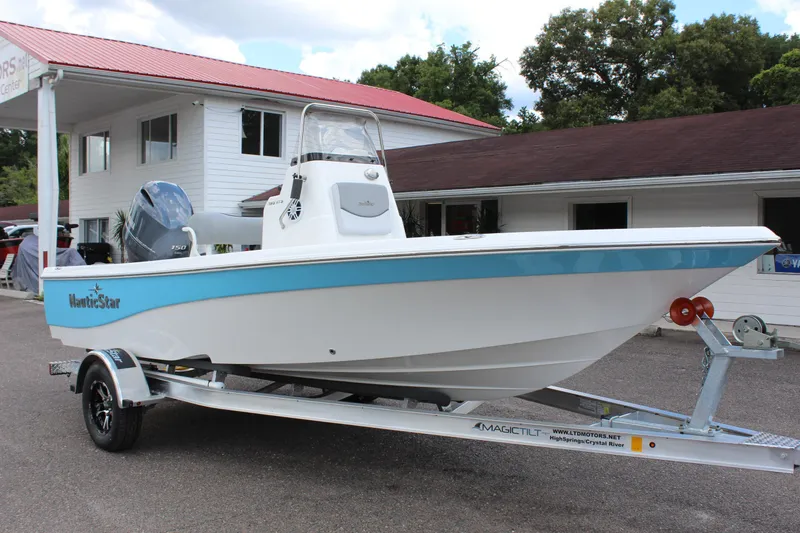 Slide: The Image of 2022 NauticStar 195 XTS boat on trailer outside building. - 9