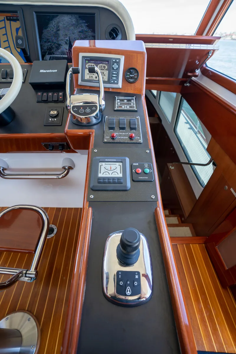 Slide: The Image of Control panel of a 2008 Huckins Linwood yacht with navigation and throttle controls. - 12