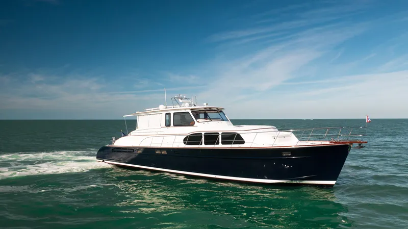 Slide: The Image of 2008 Huckins Linwood yacht cruising on open water under a clear blue sky. - 2