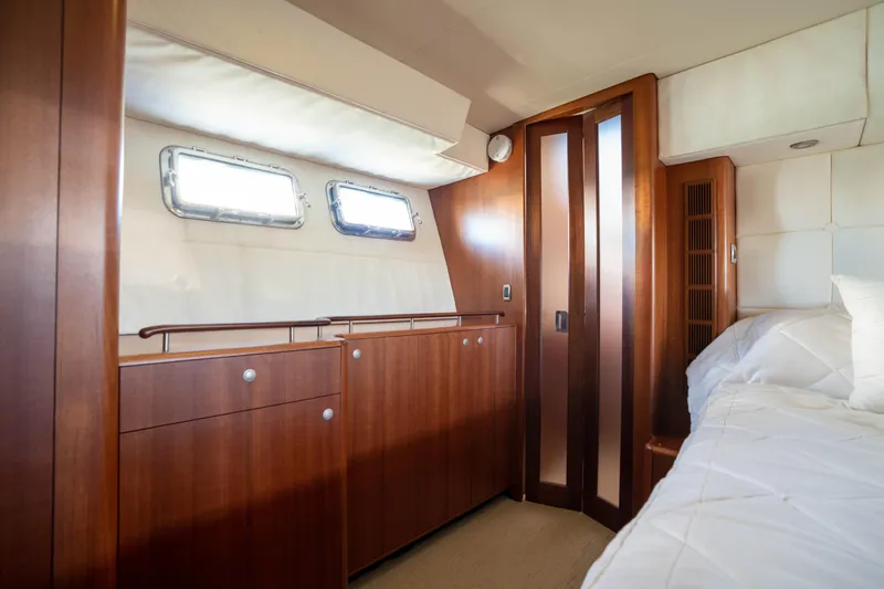 Slide: The Image of Luxurious cabin interior of a 2008 Huckins Linwood yacht with wooden cabinetry and porthole windows. - 32