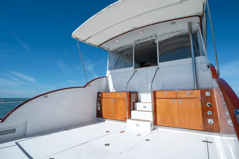 Slide: The Image of 2008 Huckins Linwood yacht deck with wooden cabinets and white flooring. - 9