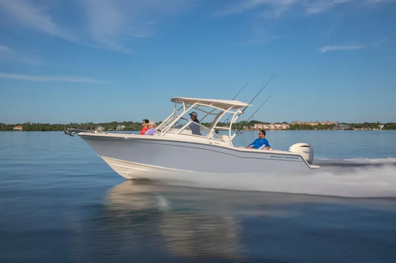 Slide: The Image of 2025 Grady-White Freedom 235 boat cruising on calm water under clear blue sky. - 1
