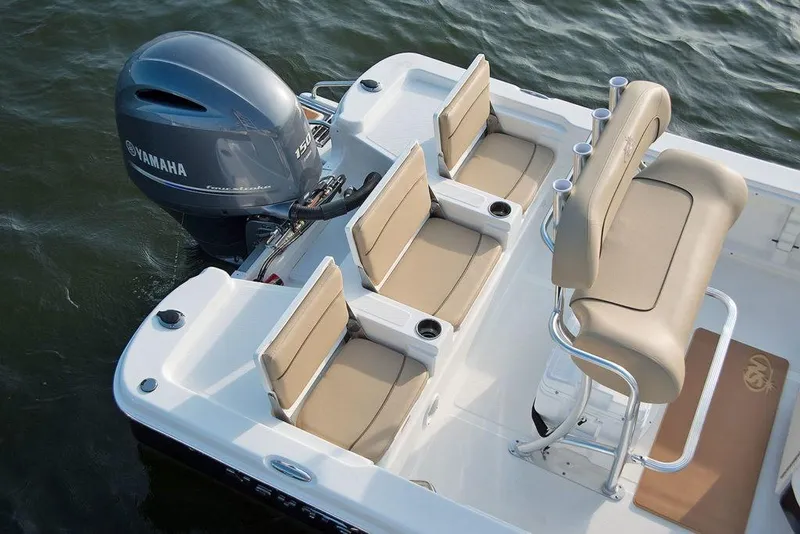 Slide: The Image of 2023 NauticStar 215 Bay boat with Yamaha engine, beige seating, and rod holders. - 11