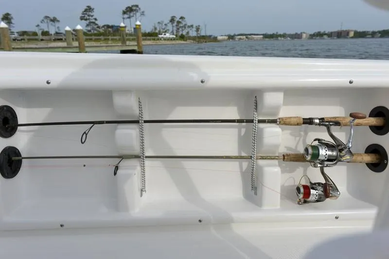 Slide: The Image of Fishing rod holders on a 2023 NauticStar 215 Bay boat, docked by the water. - 22