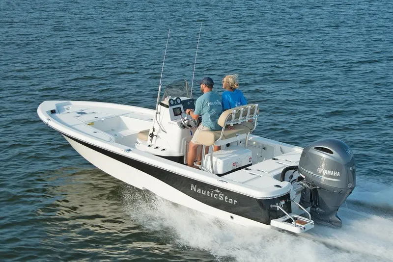 Slide: The Image of 2023 NauticStar 215 Bay boat cruising on water with two passengers. - 3