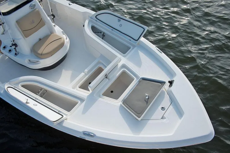 Slide: The Image of 2023 NauticStar 215 Bay boat with open storage compartments on the water. - 7