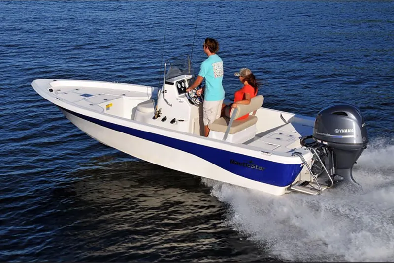 Slide: The Image of 2023 NauticStar 195 Bay boat cruising on water with two passengers. - 4