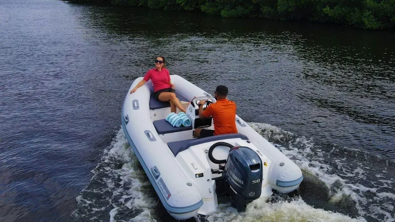 Slide: The Image of 2024 Northstar Axis 3.8 inflatable boat cruising on a river with two passengers. - 1