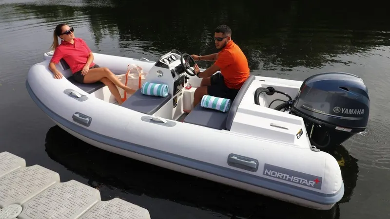 Slide: The Image of 2024 Northstar Axis 3.8 inflatable boat with Yamaha engine on the water. - 3
